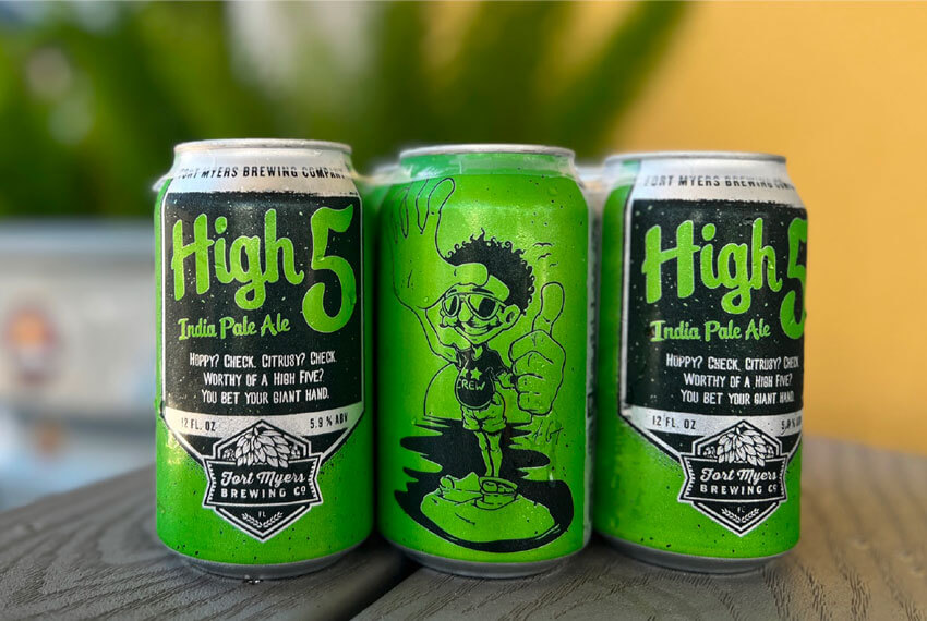Three cans of high 5 beer sitting on a table.