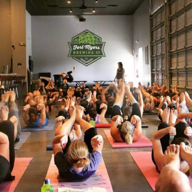 a group of people doing yoga in a large room.