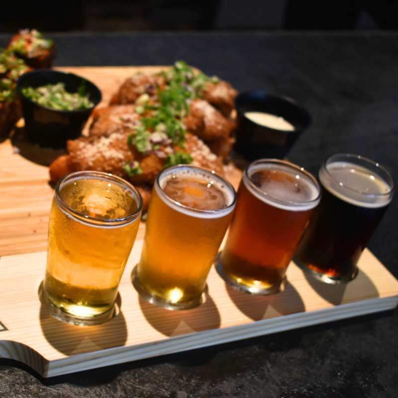 a tray of beers on a wooden board.